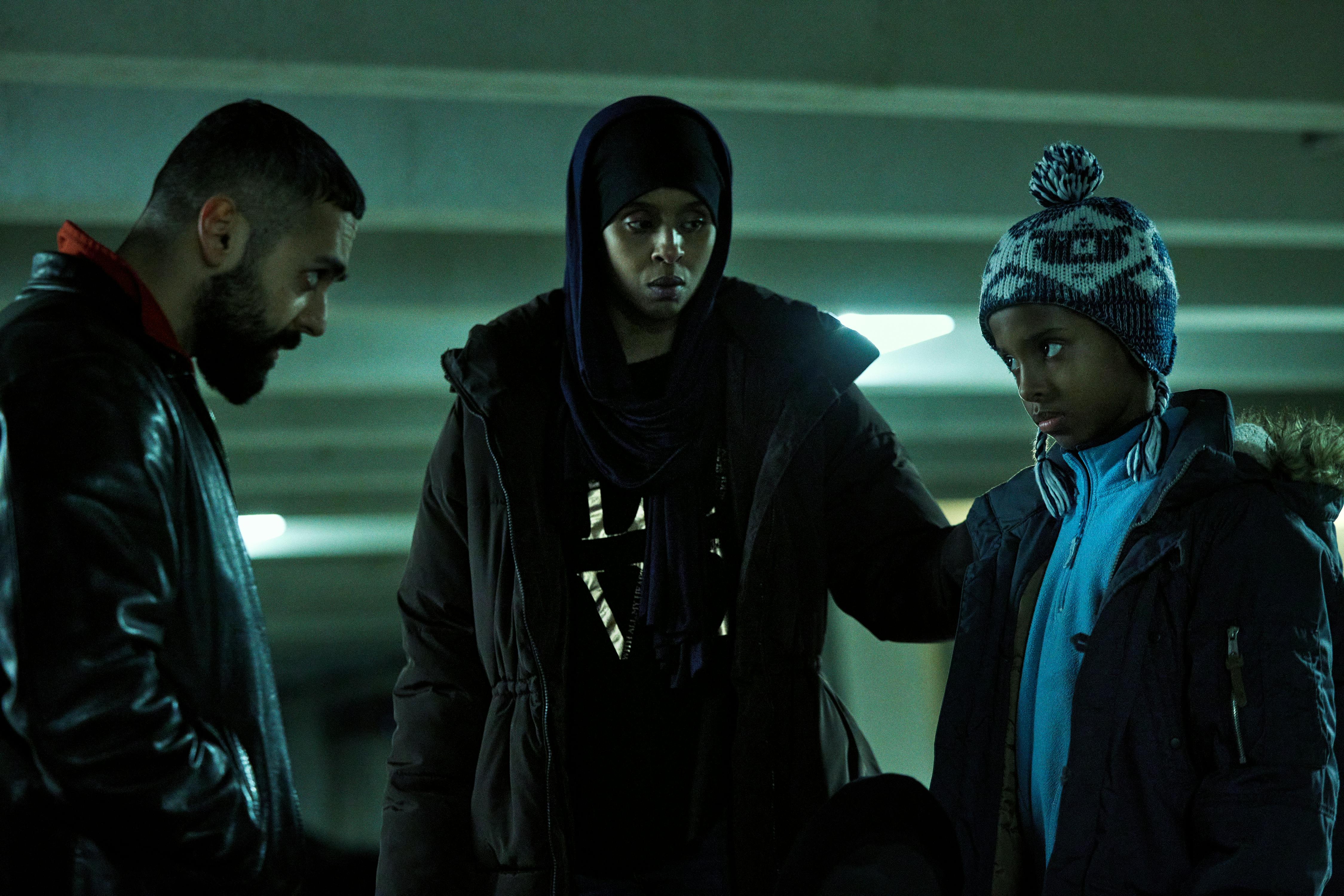 Deliver Me. Ardalan Esmaili as Farid, Hidaya Awes as Aisha and Abdirahman Mohamed as Tusse in Deliver Me. Cr. Courtesy of Netflix © 2023