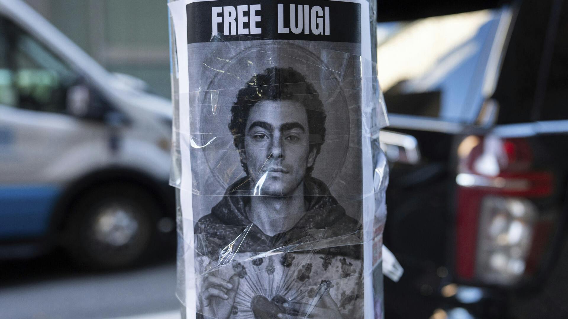 A poster depicting Luigi Mangione hangs outside the New York Hilton Midtown hotel, in New York, Dec. 12, 2024. (AP Photo/Julia Demaree Nikhinson)