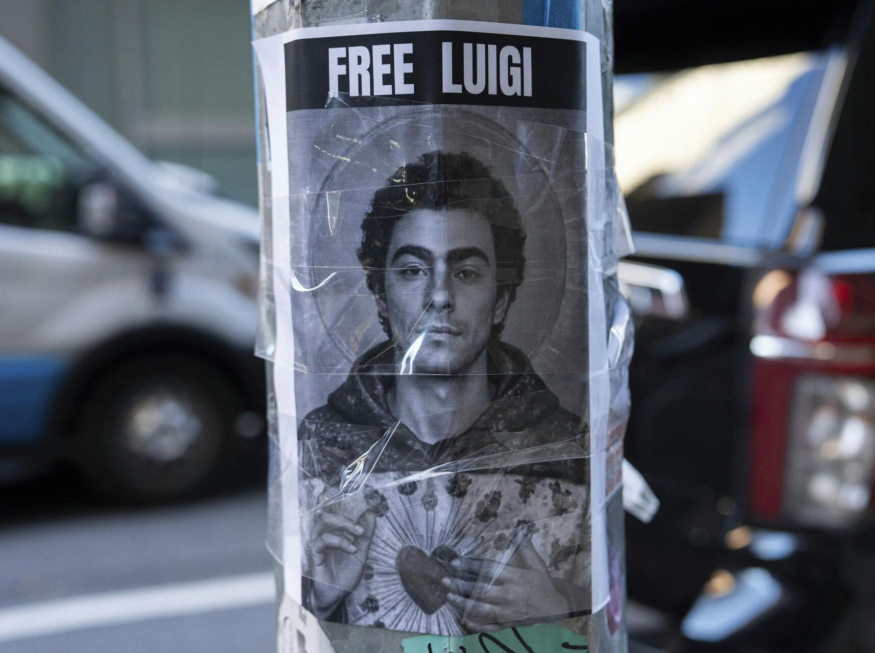 A poster depicting Luigi Mangione hangs outside the New York Hilton Midtown hotel, in New York, Dec. 12, 2024. (AP Photo/Julia Demaree Nikhinson)