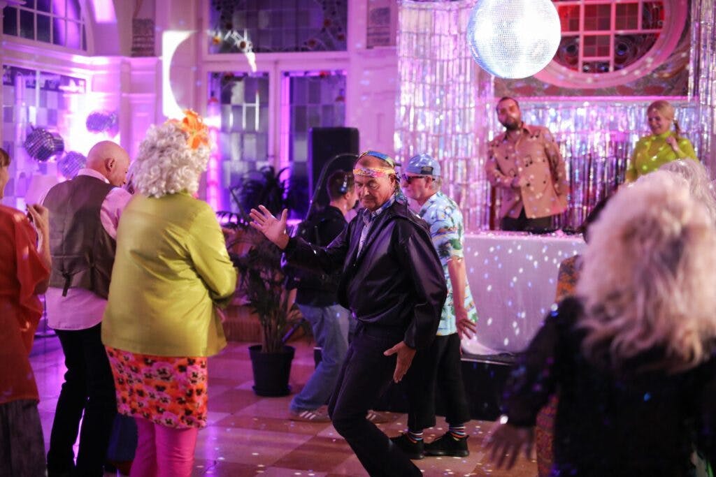 70-årige Ole fra Lyngby forsøger at charme sig lidt ind på Anette, der her er klædt i fuld 70’er-mundering.