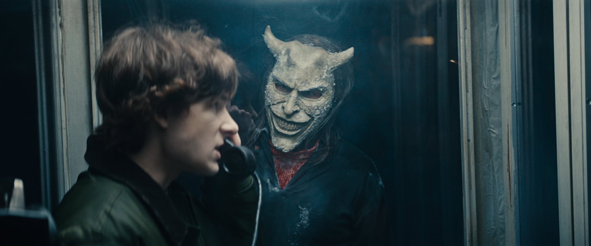 (from left) Finn (Mason Thames) and The Grabber (Ethan Hawke) in Black Phone 2 anmeldelse, written and directed by Scott Derrickson.